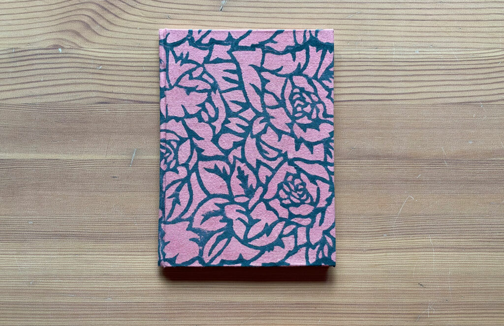 closed book showing pink dyed and flower printed bookcloth cover, Untitled artist’s book, 2020, Artist’s book, single section case binding structure, pages are made with archival Okawara paper, woodcut prints on endsheets and spread on Kitakata paper